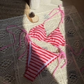 Dettaglio bikini a righe rosa e rosse con trama in maglia su pizzo decorativo - Rosa
