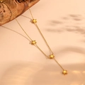 Dettaglio di una collana a Y dorata in titanio con quattro ciondoli a stella - Collana Stella d'Oro (H114)