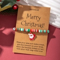 Close-up of Christmas wish bracelet with colorful clay beads and enamel Santa pendant - Classic Santa Claus