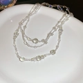 Detail of layered clear glass beads on a white ceramic plate showing refined craftsmanship - Iridescent White