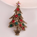 Primer plano de broche de árbol de Navidad dorado vintage con brillantes de colores - Oro Antiguo