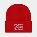 Detail of red knit beanie with white embroidered motivational quotes on the folded cuff - Red