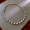 Dettaglio di perle naturali e pietre verdi su una collana a catena dorata vintage - Oro