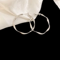 Close-up of irregular twisted silver hoop earrings on elegant white silk fabric - Silver Earring Post Twisted Hoop Earrings