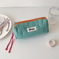 Detail of green plaid canvas pencil case featuring a bright orange zipper and pink tassel - Green
