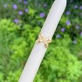 Eleganter 18K vergoldeter Schleifenring mit Zirkonia-Steinen auf einem Schmuckständer - Schleife-Stil