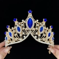 Golden baroque bridal crown with blue gemstones and crystals held against black background - Standard Size / Gold Plated Blue Zirconia