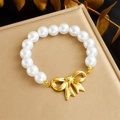 Close-up of pearl bracelet featuring a golden bow pendant and lustrous white pearls - Bowknot Bracelet (B1398)