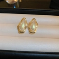 Detailed shot of vintage gold pearl earrings with iridescent mother-of-pearl insets - Gold Teardrop Style
