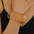 Makroaufnahme eines mehrlagigen goldenen Spiralarmbandes am Handgelenk einer Frau - Mehrschichtiges Spiral-Elastik-Armband / Gold (KC Gold 7841)