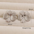 Pair of silver minimalist flower earrings in 30mm size shown on a jewelry display mat - Silver