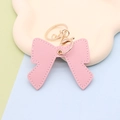 Portachiavi a fiocco in pelle PU rosa con dettagli dorati su vassoio decorativo - Stile portachiavi / Fiocco rosa chiaro