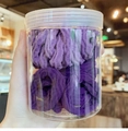Detail of purple gradient ribbed hair ties in a clear jar with high elasticity textures - Purple