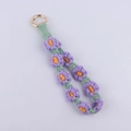 Close-up of handmade woven floral charm with purple daisies and gold spring buckle - Purple