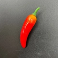 Lifelike artificial red chili foam model with green stem on dark textured background - Mini Red Yellow Chili