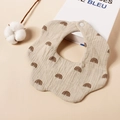 Detail van een bloemvormige baby-slabbetje van beige katoenen gaas met regenboog-print - Grijze Regenboog