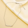 Macro detail of silver mami pendant and S.STEEL hallmark on polished heart necklace - Silver Necklace