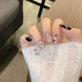 Close-up of press-on nails with 3D floral accents and glitter on a natural manicure - By1713 Black And White Floral / Phototherapy Glue Style