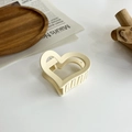 Dettaglio di un elegante fermaglio per capelli color crema a cuore su vassoio in legno - Cuore / Beige