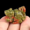 Miniature unakite gemstone rabbit sculpture held between fingers for size reference - Unakite