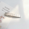 Detail of white marble textured acrylic hair clip on a minimalist floral display card - Ivory