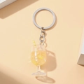 Close-up of a luminous goblet keychain with lemon slices, ice cubes and straw - Orange