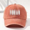 Vintage washed orange baseball cap with FOCUS print shown in a minimalist studio setting - One Size / Orange