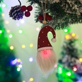 Lighted Christmas gnome hanging ornament with red polka dot hat on festive tree branch - Red Hat Dots