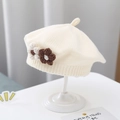 Knitted baby beret in cream white with decorative crochet flowers on a display stand - Double Flower Knit Beret / Off White