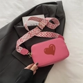 Pink crossbody camera bag with red heart detail and geometric patterned shoulder strap - Pink