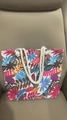 Canvas tote bag with vibrant tropical leaf patterns and white rope handles shown on chair - Pink Blue Flower