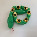 Articulated green plastic toy snake with colorful eye patterns and flexible joints - Green