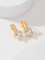 Nahaufnahme von goldenen Herz-Zirkonia-Ohrringen auf minimalistischem Steinsockel - Weiß