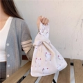 Detail of a minimalist linen wrist bag with rabbit print and Japanese knot handle design - Rabbit Head