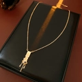 Close-up of golden tassel necklace with zircon stones on a black leather display - Necklace - Gold (Gold Plated)