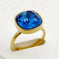 Détail macro d'une bague en acier doré sertie d'un grand zircon carré bleu facetté - Style Carré / Bleu marine