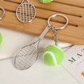 Close-up of a silver tennis racket and a green plush tennis ball on a sporty keychain - Racket With Clasp / Large Green Tennis Ball