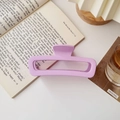 Détail d'une pince à cheveux rectangulaire violet mat sur un livre ouvert - Carré Grand Mat Rose Violet