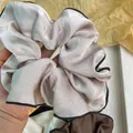 Chouchou géant en satin champagne avec bordure noire et plis élégants et soyeux - Style satiné haute brillance / Abricot Lacté