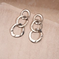 Macro shot of gold-layered triple hoop earrings with a hammered texture finish - Silver