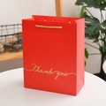 Macro shot of red gift bag with golden Thank you text and braided rope handles - Red Bronzing - Small / 14x7x15.5cm