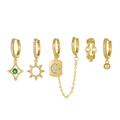 Set di orecchini dorati con luna, stelle, gemme verdi e catene su sfondo bianco - Oro