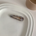 Detail of elegant acetate duckbill hair clip with marble pattern on ceramic tray - Grey Marble Water Drop