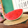 Cute plush watermelon slice toy with red pulp and black seed embroidery on a woven mat - Watermelon