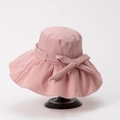 Detail of pink wide brim sun hat with ribbon bow and textured fabric on wooden stand - M (56-58cm) / Pink
