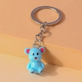 Detail of blue bear keychain with pink inner ears and matte finish on orange background - Blue
