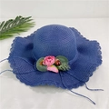 Détail d'un chapeau de paille bleu marine avec bord ondulé et fleurs roses décoratives - Bleu Marine