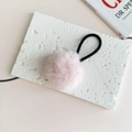 Close-up of pink fluffy pompom hair tie on a white stone background for a sweet style - Light Pink