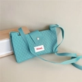 Detail of teal knitted crossbody bag featuring a diamond texture and magnetic buckle - Cyan