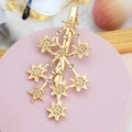 Dettaglio di un fermaglio per capelli dorato a forma di stella con strass incastonati - Stile 07-Forma di Stelle